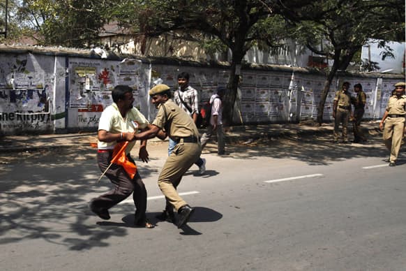 A policeman detains a worker who tried to march towards the state legislature complex on the first day of a two day strike in Hyderabad.