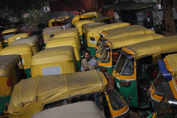 A auto-rickshaw driver stands among dozens of auto-rickshaws parked during a nationwide strike called by trade unions in New Delhi.