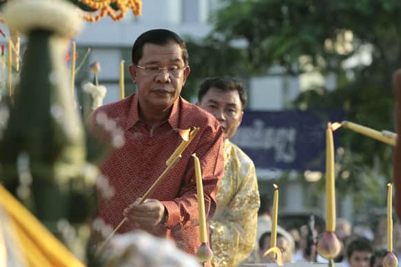 Cambodian Prime Minister Hun Sen lights candles during a ground breaking ceremony for the site where a statue of Cambodia`s late King Norodom Sihanouk will be built, in front of Independence Monument in Phnom Penh.