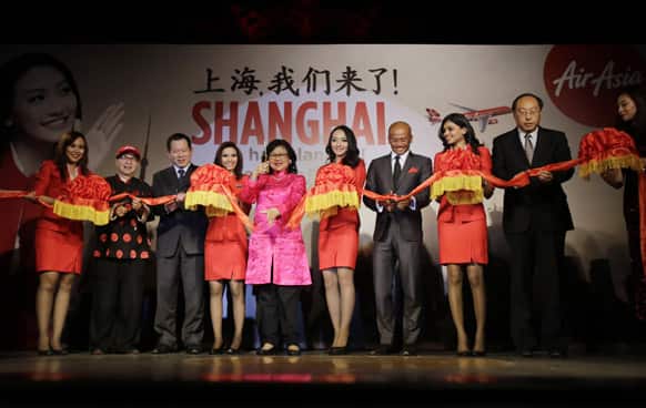 AirAsia X CEO Azran Osman-Rani, fourth from right, and Chairman Tan Sri Rafidah Aziz, fifth from left, attend a ribbon-cutting ceremony to celebrate budget carrier AirAsia’s inaugural flight to Shanghai, in Shanghai, China.