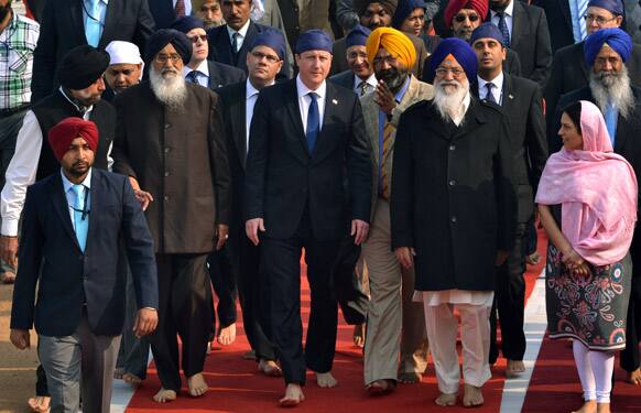 British Prime Minister David Cameron, center, visits the Golden Temple, Sikh’s holiest shrine, along with Chief Minister of Punjab state Parkash Singh Badal, second from left wearing glasses, in Amritsar.