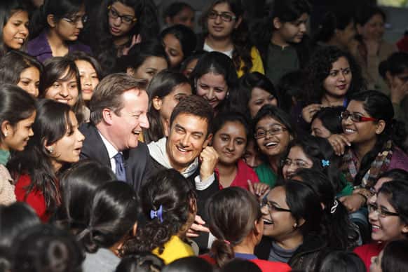 British Prime Minister David Cameron, center left, and Bollywood actor & UNICEF ambassador to promote child nutrition Aamir Khan, center, smile as they meet students at the Janaki Devi Memorial College in New Delhi.