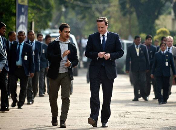 British Prime Minister David Cameron, right, and Indian Bollywood actor Aamir Khan, left, arrive at the Janki Devi Memorial College in New Delhi.