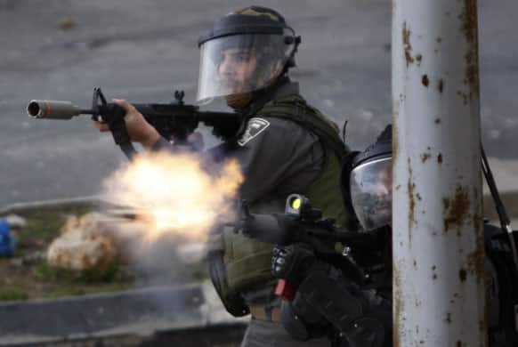 An Israeli border policeman fires with anti-riot ammunition towards Palestinian demonstrators, not pictured, during a protest to support Palestinian prisoners, outside Ofer, an Israeli military prison near the West Bank city of Ramallah.