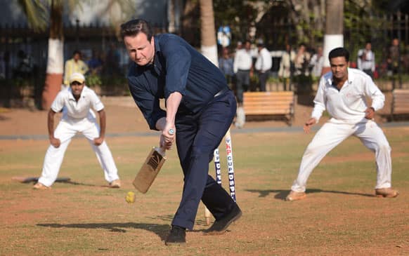 Britain`s Prime Minister David Cameron plays cricket with Indian boys at the Oval Maidan, a communal cricket pitch in the centre of Mumbai.