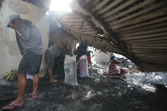 Filipinos salvage reusable items under a collapsed roof after fire gutted residential homes in suburban Valenzuela, north of Manila.