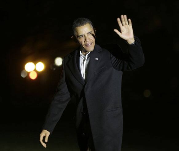 President Barack Obama waves to members of the media as walks across the South Lawn of the White House following his arrival on Marine One helicopter.