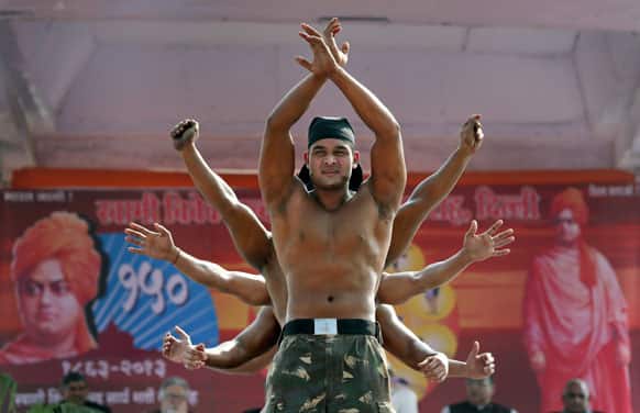 Indian bodybuilders perform before Surya Namaskar or Sun salutation during a function to mark 150th birth anniversary of Swami Vivekananda, in New Delhi.