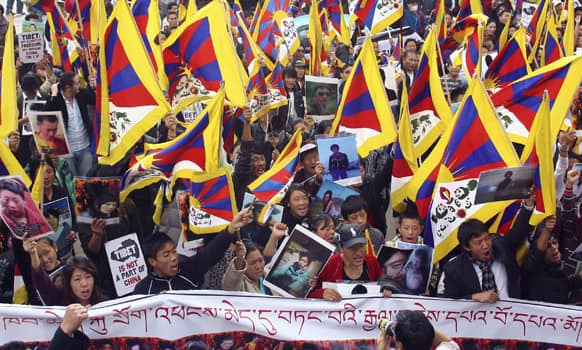 Exile Tibetans wave Tibetan flags and display photos of Tibetans who died in self-immolation as they demonstrate in Dharamsala.