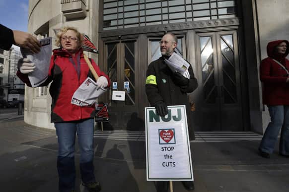BBC journalists hand out leaflets as they mount picket lines after launching a 24-hour strike in a row over jobs, outside the BBC Broadcasting House, in central London.