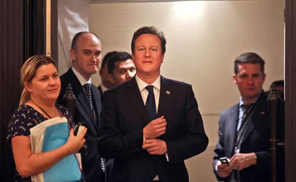 British Prime Minister David Cameron, center, arrives to deliver a speech at a business seminar in Mumbai.