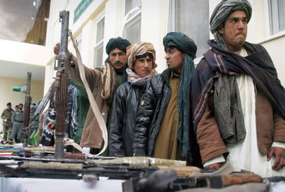Former Taliban militants who have turned in their weapons stand during a ceremony with the Afghan government in Herat, Afghanistan. About 35 former Taliban militants from Herat province handed over their weapons as part of a peace-reconciliation program.