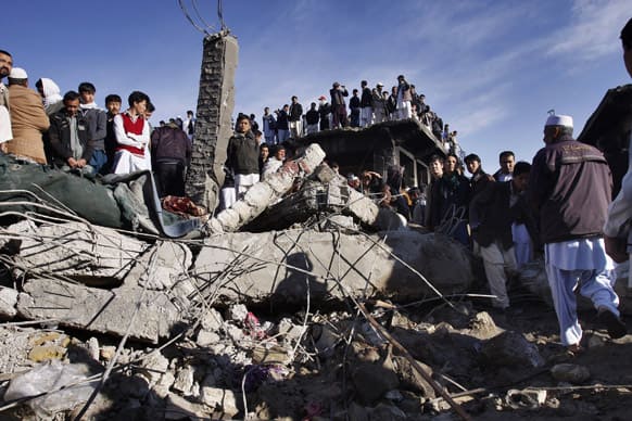 Local residents stand over the rubble of a damaged market caused by Saturday`s bombing in Quetta, Pakistan.