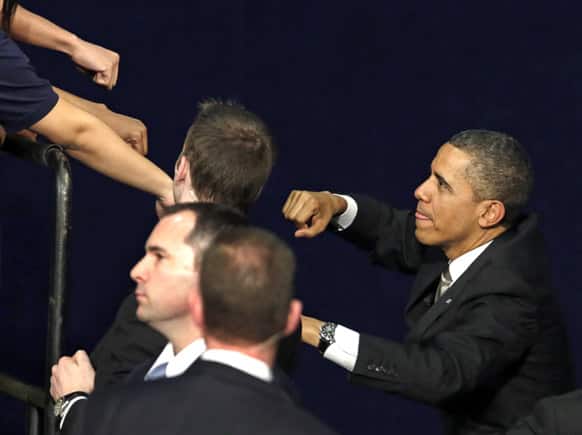 President Barack Obama acknowledges the crowd as he exchanges fist bumps with the audience after speaking at Hyde Park Academy, in Chicago.