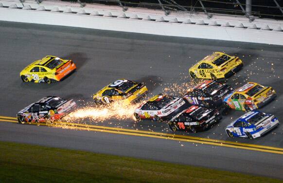 Tony Stewart (14) sends sparks flying, as drivers behind start to wreck in Turns 1 and 2 during the NASCAR Daytona Shootout auto race at Daytona International Speedway in Daytona Beach, Fla.