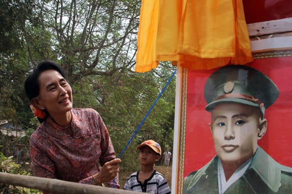 Myanmar`s opposition leader Aung San Suu Kyi unveils a signboard showing her late father General Aung San, at a branch office of her National League for Democracy party in Yangon.