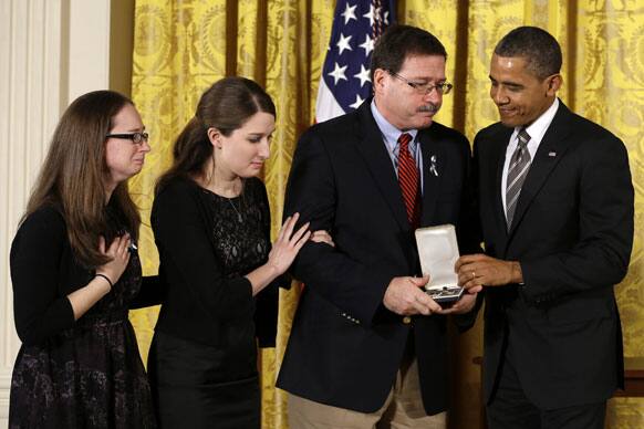 President Barack Obama presents a 2012 Citizens Medal to the family of Sandy Hook Elementary School school psychologist Mary Sherlach, in the East Room of the White House in Washington.