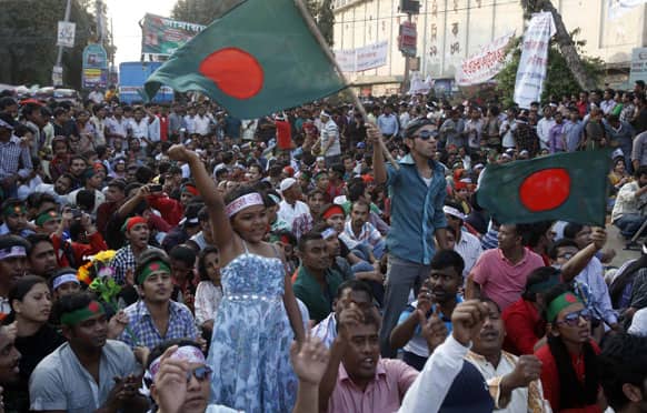 Bangladeshi activists wave national flags as they shout slogans demanding the execution of Jamaat-e-Islami leader Abdul Quader Mollah and others convicted of war crimes involving the nation`s independence war in 1971, in Dhaka, Bangladesh.