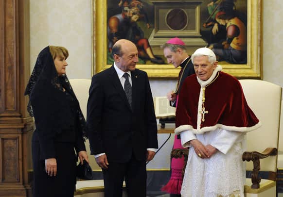 Pope Benedict XVI talks with Romania`s President Traian Basescu, center, and his wife Maria Basescu, during a private audience at the Vatican.
