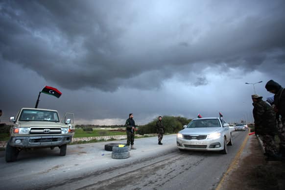 Libyan security forces check the cars on the side of the highway leading to downtown Benghazi, Libya. Libyans are preparing to mark the second anniversary of the uprising that ousted Moammar Gadhafi.