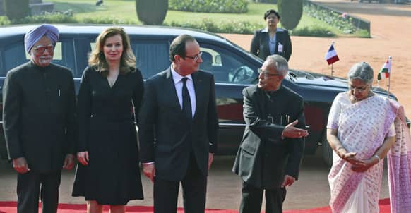 French President Francois Hollande, watches as Indian President Pranab Mukherjee, introduces Indian Prime Minister Manmohan Singh`s wife Gursharan Kaur, during a ceremonial reception in honor of Hollande, at the presidential palace in New Delhi.