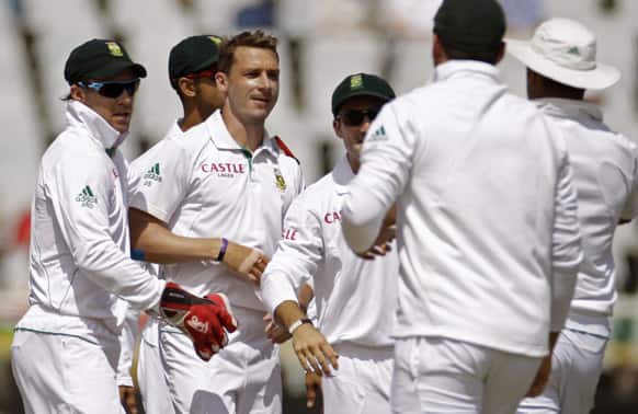 South Africa`s Dale Steyn, second left, reacts with team members after taking the wicket of Pakistan Mohammad Hafeez, unseen, during a five day test series in Cape Town, South Africa.