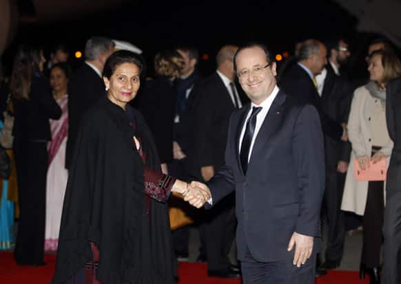 French President Francois Hollande shakes hands with India`s Junior Foreign Minister Preneet Kaur, upon arrival at the Palam Technical airport in New Delhi.