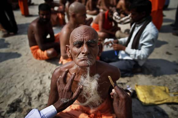 Hindu holy men get their beard and head shaved before being initiated as Naga sadhus or naked Hindu holy men at the Maha Kumbh festival in Allahabad.