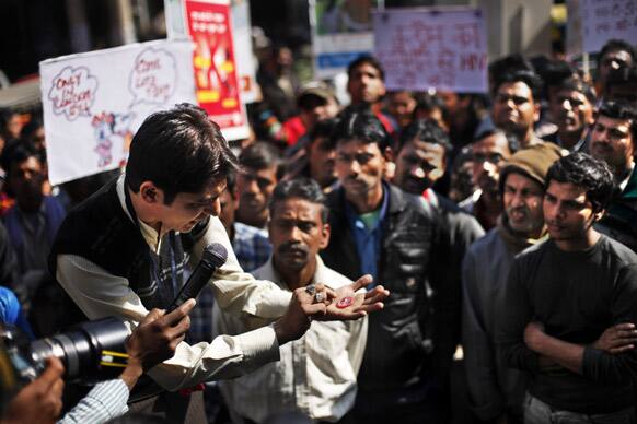 People watch as a volunteer of AIDS Healthcare Foundation (AHF) demonstrates the use of a condom at a red light area in New Delhi. AHF is observing Feb.13, the eve of Valentine’s Day as International Condom Day.