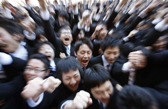 Students from vocational schools in Tokyo punch the air with their fists during a pep ceremony to launch their job-hunting in Tokyo.