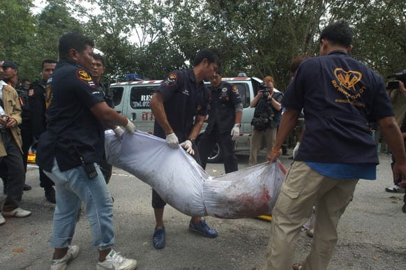 Thai volunteer rescue workers remove a dead body of an insurgent in Narathiwat province, Thailand. Marines fending off a major militant assault on their base in Thailand’s violent south killed 16 insurgents in an overnight shootout, authorities said Wednesday.