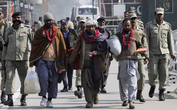 Pakistani prisoners who are released by India cross over to Pakistan flanked by Pakistani border personnel at Wagah border post near Lahore.