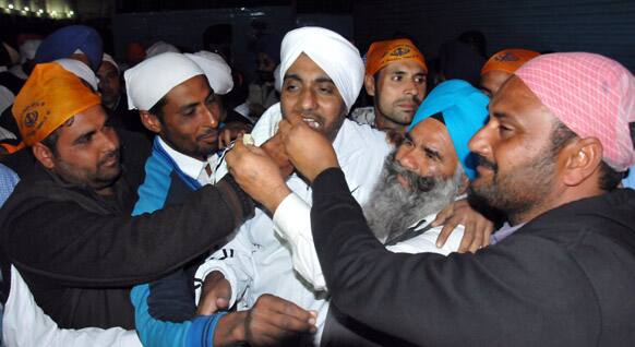 Indians feed sweets to a family member who was on death row in United Arab Emirates and recently freed by a Sharjah court, upon his return home in Amritsar.