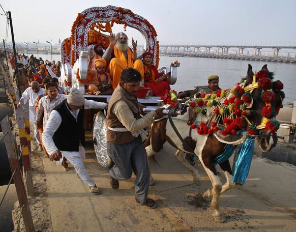 Disciples help a carriage over an incline as a Hindu holy man participates in a procession at the Maha Kumbh festival in Allahabad.