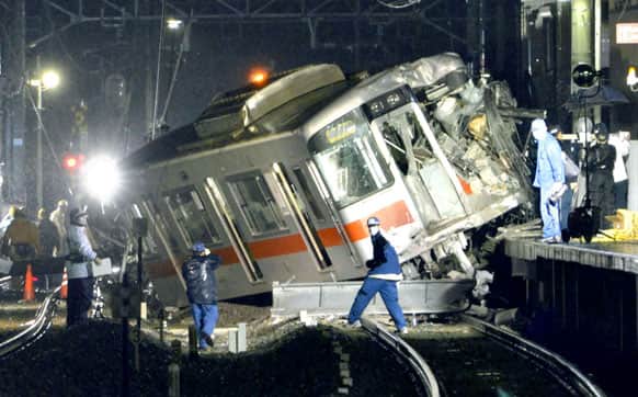 A derailed train is seen on a station platform after a collision at a railway crossing in Takasago, Hyogo prefecture. A commuter train collided with a truck at a railway crossing in southern Japan on Tuesday, injuring more than a dozen people.