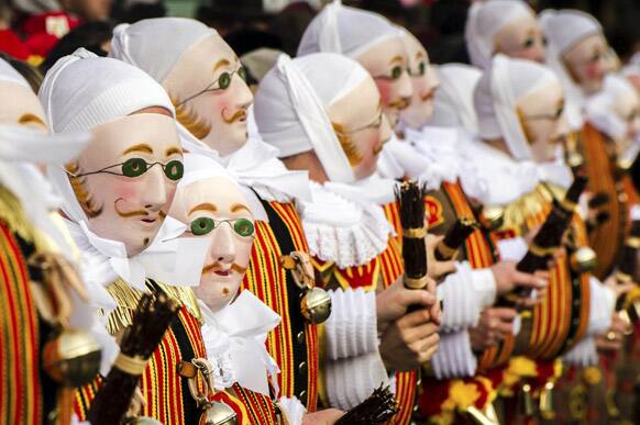 A group of people dressed as `Gilles of Binche`, arrive to pick up their jubilee medals at the City Hall on the Grand Place, during the Carnival of Binche, in Binche, Belgium.