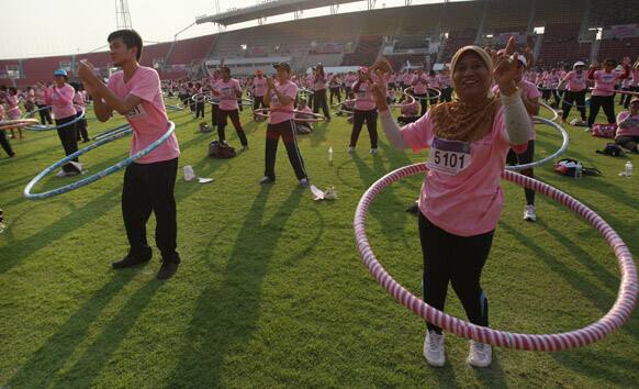 Participants perform in a hula hoop competition to break the Guinness World Record for most people dancing with hula hoops, at Thammasat University, Pathumthani, Thailand.