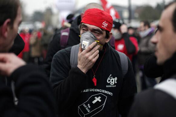 A worker of tyre manufacture Goodyear adjusts his mask to protect from tear gas during a demonstration in front the Goodyear headquarters, in Reuil Malmaison, outside Paris. US tyremaker Goodyear confirmed in January to close a French plant, which would lead to the layoff of 1,173 jobs.