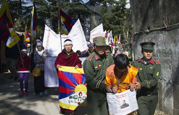 Exiled Tibetans stage a street act with mock Chinese armed personnel keeping a Tibetan in chains during a protest gathering in solidarity with the Tibetan immolators in Dharmsala.