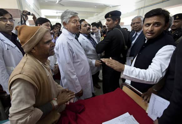 Uttar Pradesh Chief Minister Akhilesh Yadav, speaks with a survivor of a stampede at a railway station, during a visit to meet with injured pilgrims at a local hospital in Allahabad.