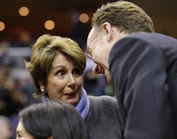 House Minority Leader Nancy Pelosi, of California, left, speaks with Georgetown president John J. DeGioia during the second half of an NCAA college basketball game against Marquette in Washington.