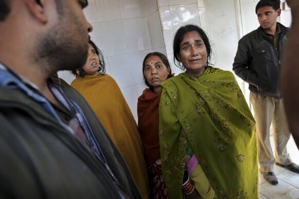 Relatives of a Hindu devotee who died in a stampede at a railway station, arrive to identify the body of a loved one at a local morgue in Allahabad.
