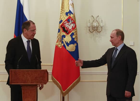 Russian President Vladimir Putin greets Foreign Minister Sergei Lavrov, left, during a meeting with Foreign Ministry officials at the Novo-Ogaryovo residence outside Moscow.