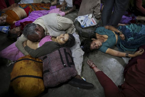 An Indian man weeps as he holds his wife who was killed in a stampede on a railway platform as other bodies are seen beside at the main railway station in Allahabad.