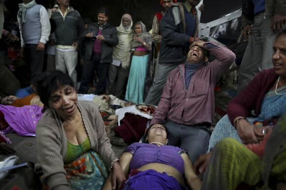 An Indian man weeps as he and other family members mourn next to the body of a relative who was killed in a stampede on a railway platform at the main railway station in Allahabad.