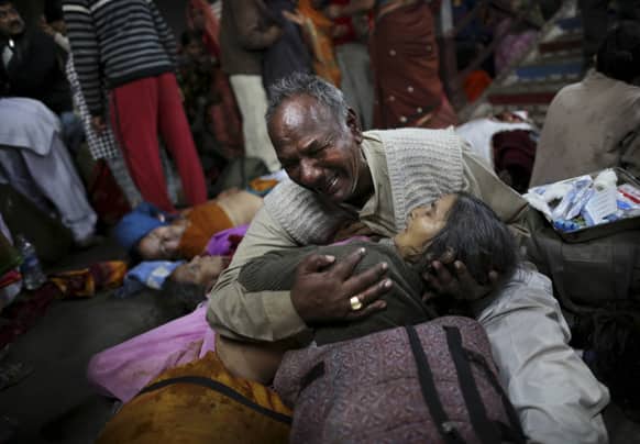 An Indian man weeps as he holds his wife who was killed in a stampede on a railway platform at the main railway station in Allahabad.