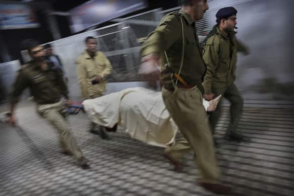 Indian police carry the body of a pilgrim who was killed in a stampede on a railway platform at the main railway station in Allahabad.