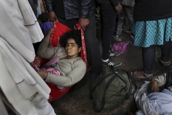 An injured Indian woman who survived a stampede on a railway platform is carried away at the main railway station in Allahabad.