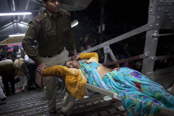 Indian police carry a pilgrim injured in a stampede at a railway platform at the main railway station in Allahabad.