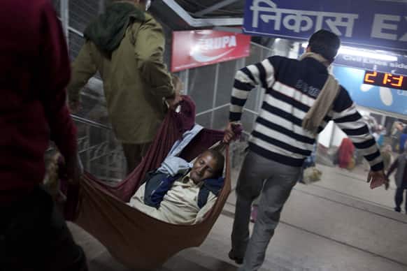 The body of a pilgrim is carried away after he was killed in a stampede on a railway platform at the main railway station in Allahabad.